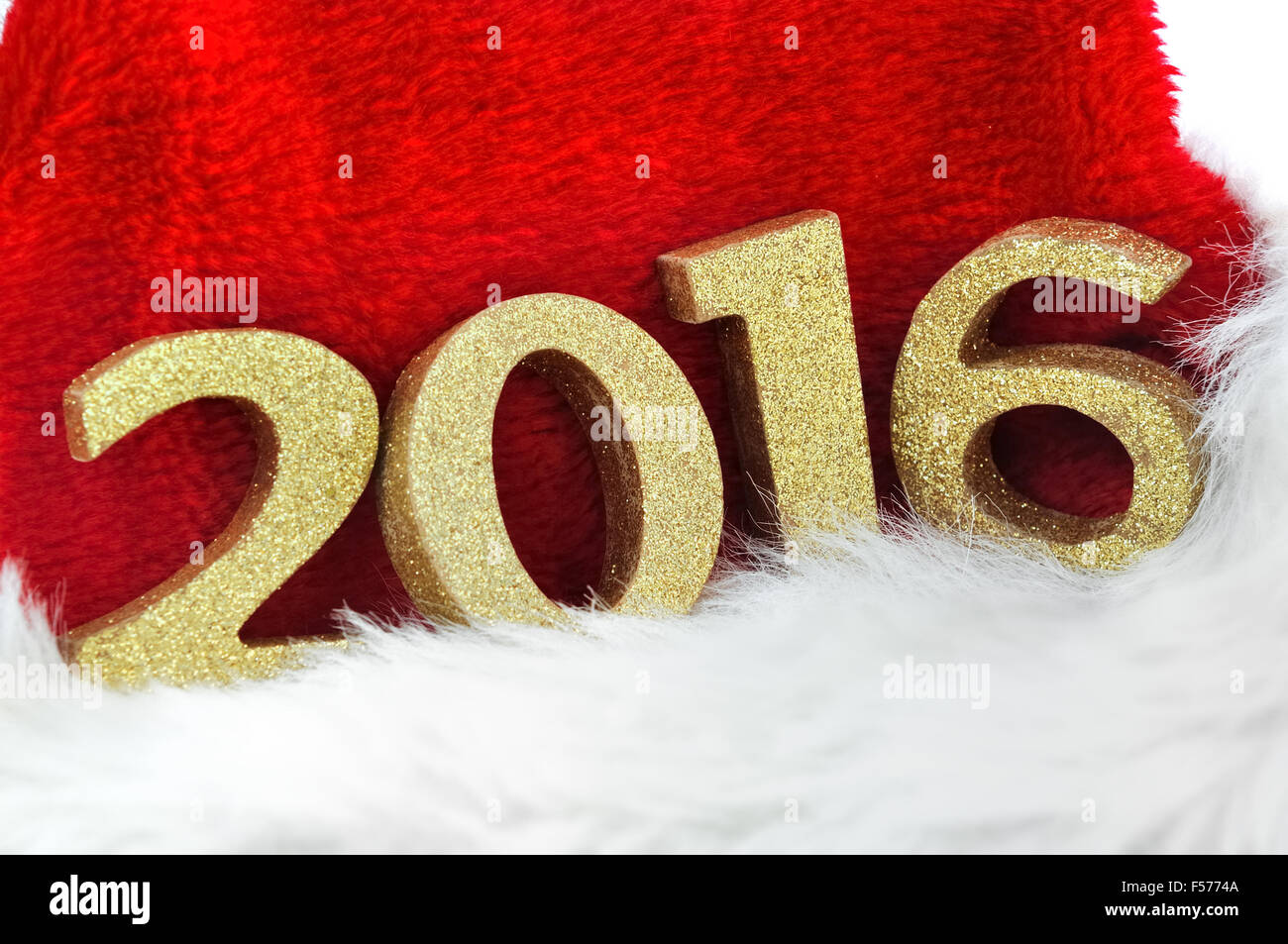 Près de 2016 sur les chiffres d'or a santa claus hat sur fond blanc Banque D'Images
