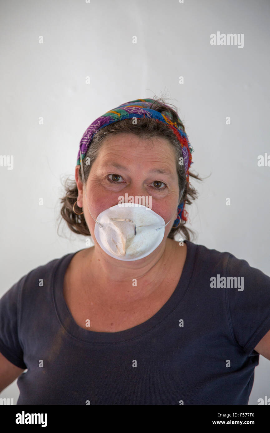 Femme d'âge moyen portant un masque DIY faire travailler à l'intérieur, England, UK Banque D'Images