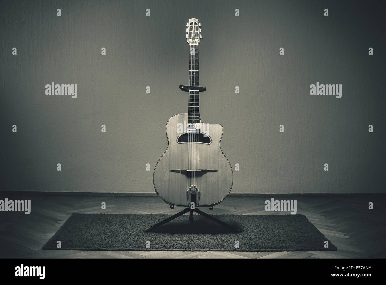 Une vieille guitare acoustique manouche sur un tapis devant un mur Photo  Stock - Alamy