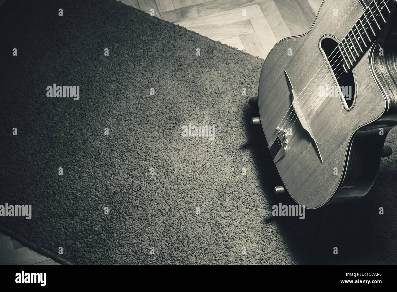 Vieille guitare acoustique manouche sur debout sur un tapis. Banque D'Images