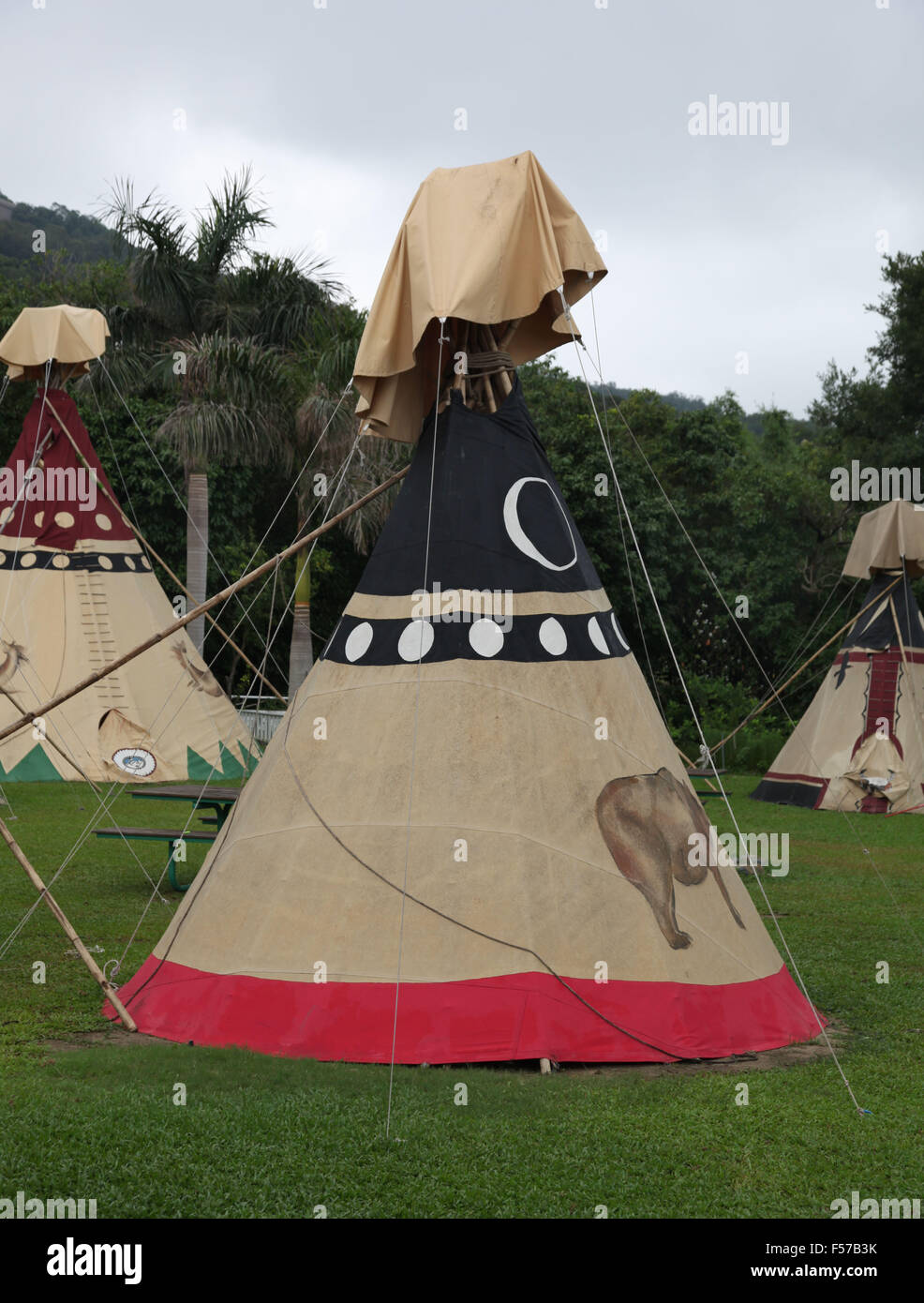 C'est une photo d'un camp indien en Amérique. Nous pouvons voir des tipis tipis ou sur l'herbe avec des forêts autour de Banque D'Images