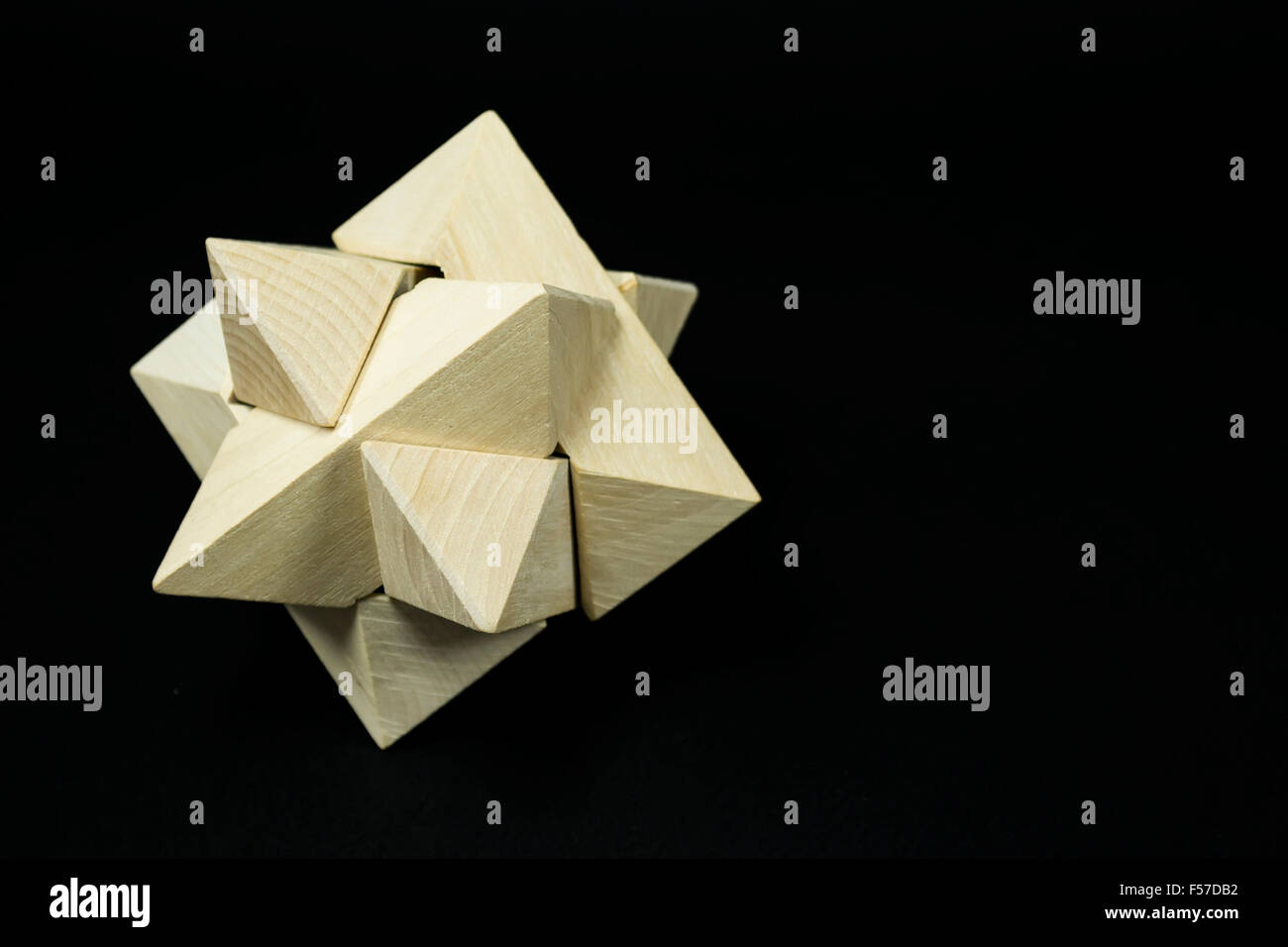 Puzzle en bois taillées dans du minéral combinées pour former un complexe star comme forme tridimensionnelle, sur fond noir Banque D'Images