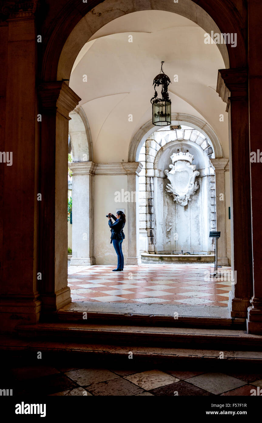 Femme prend des photos numériques dans la cour de Ca' Rezzonico, Venise, Italie Banque D'Images