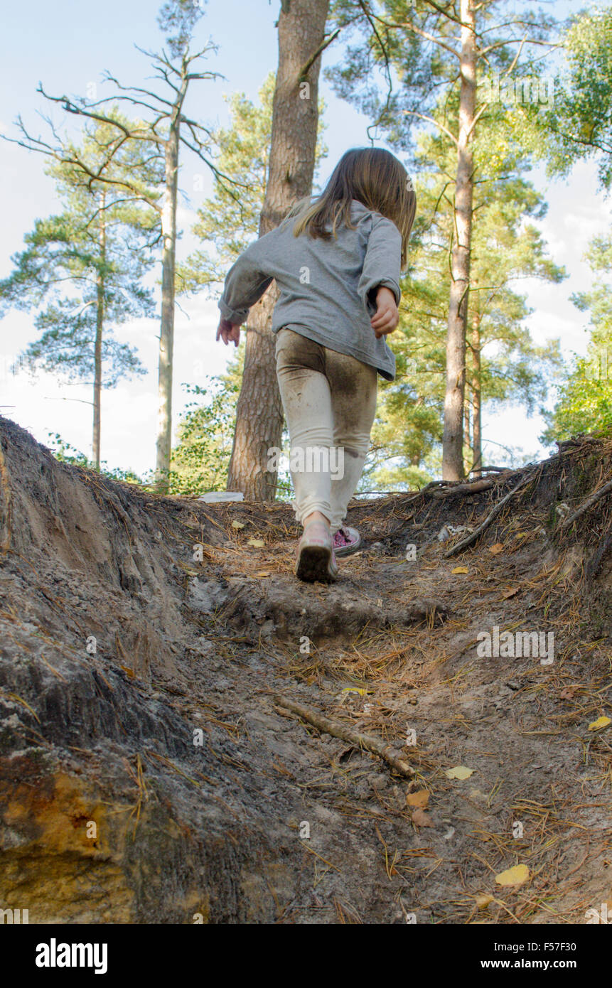 Fille de trois ans à monter un chemin boueux à travers les bois. La lecture. Le saut. Sussex, UK. Octobre. Banque D'Images Fille de trois ans à monter un chemin boueux à travers les bois. La lecture. Le saut. Sussex, UK. Octobre. Banque D'Images