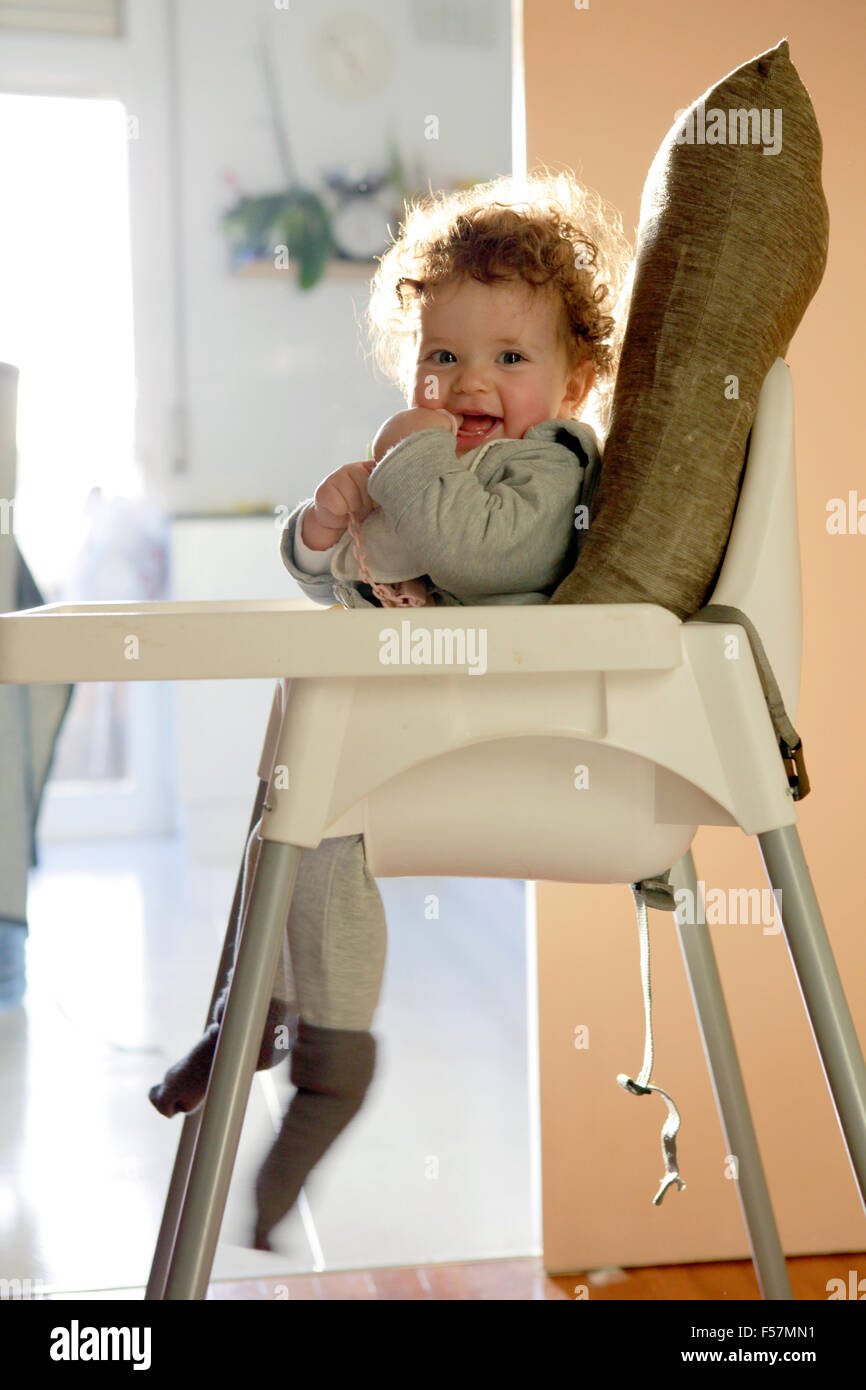 Petit bébé assis sur une chaise haute. Banque D'Images