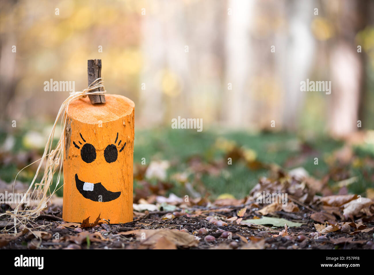 Décoratifs faits à la main ou à la citrouille jack-o-lanterne sur un lit de feuilles mortes. Soft focus sur l'arrière-plan. Copie de l'espace sur la droite. Banque D'Images