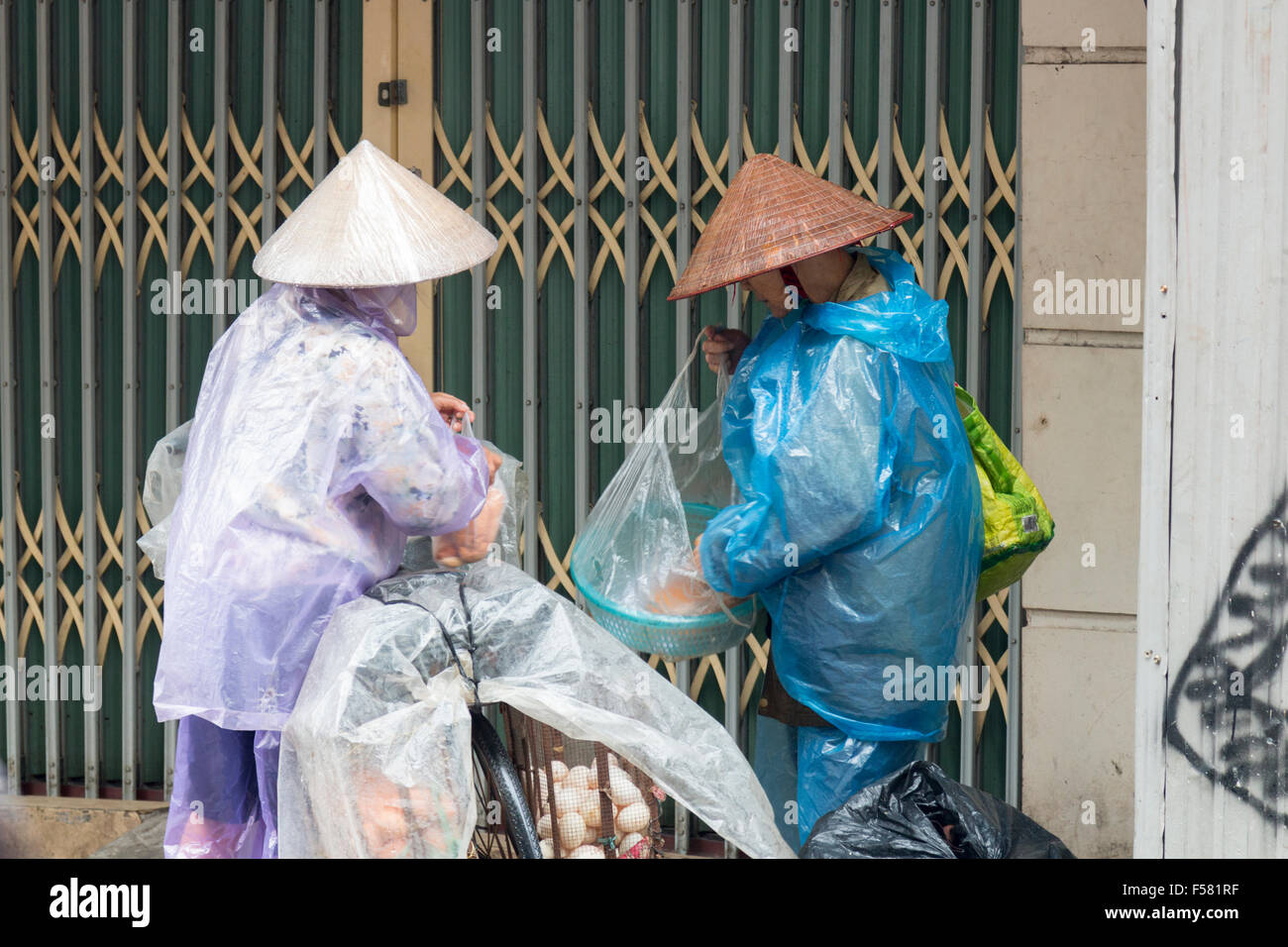 Deux vendeurs de nourriture de rue vietnamiens triant leurs produits dans le vieux quartier de Hanoi, Vietnam Banque D'Images