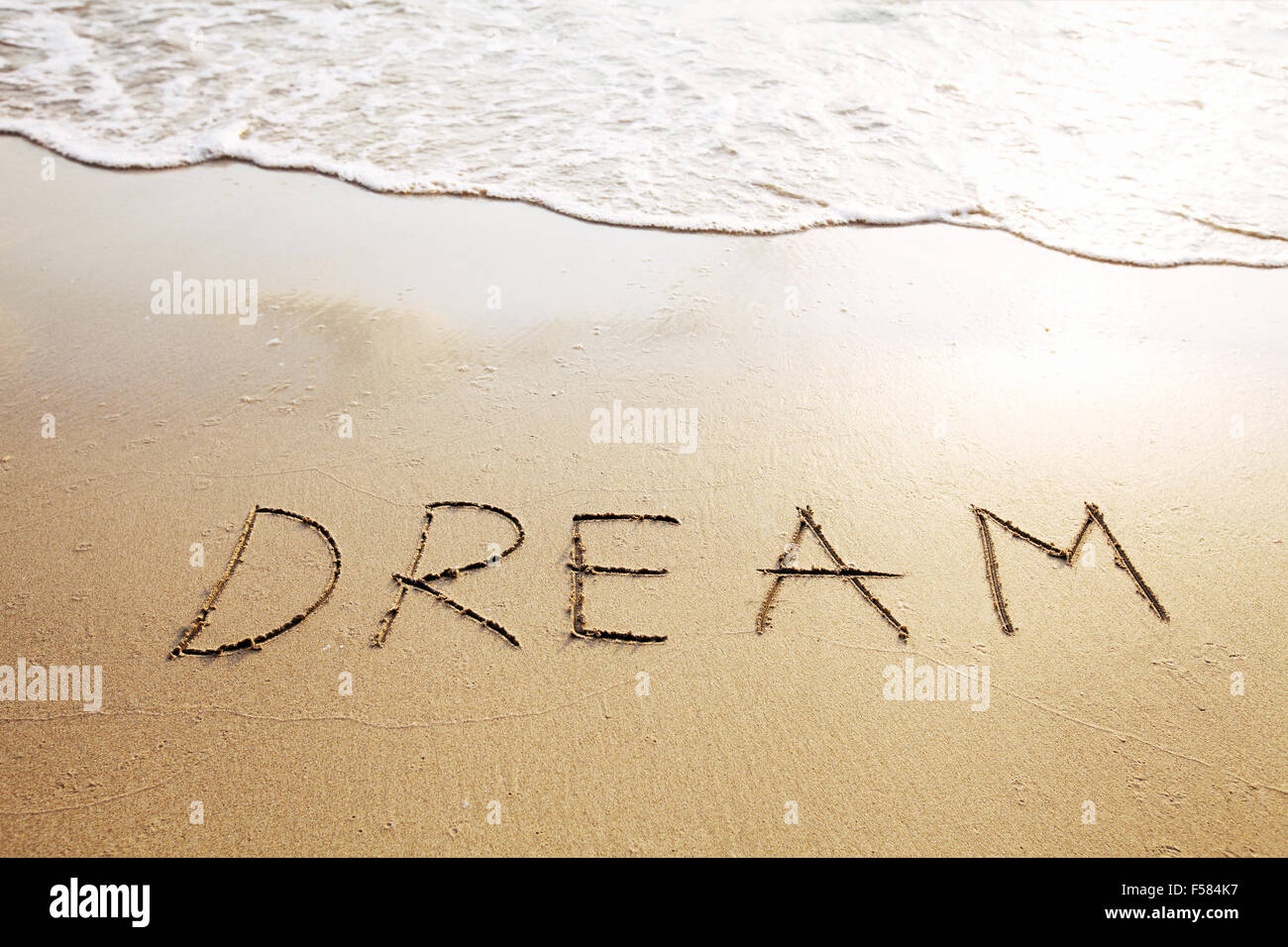 Dream - mot écrit sur la plage Banque D'Images