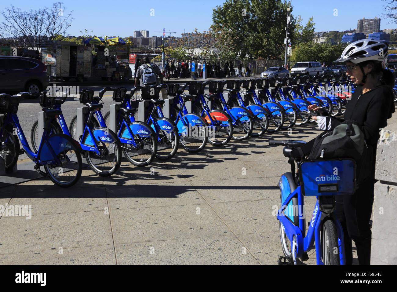 Une femelle rider avec un Citibike Citibike dans une station de partage. Côté ouest de Manhattan New York USA Banque D'Images