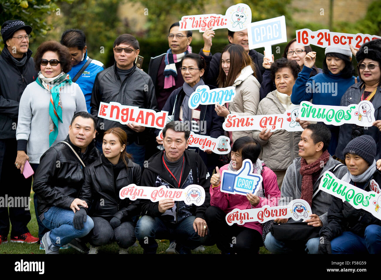 Les touristes asiatiques holding Nom plaques en différentes langues dans les Cotswolds en Angleterre Banque D'Images