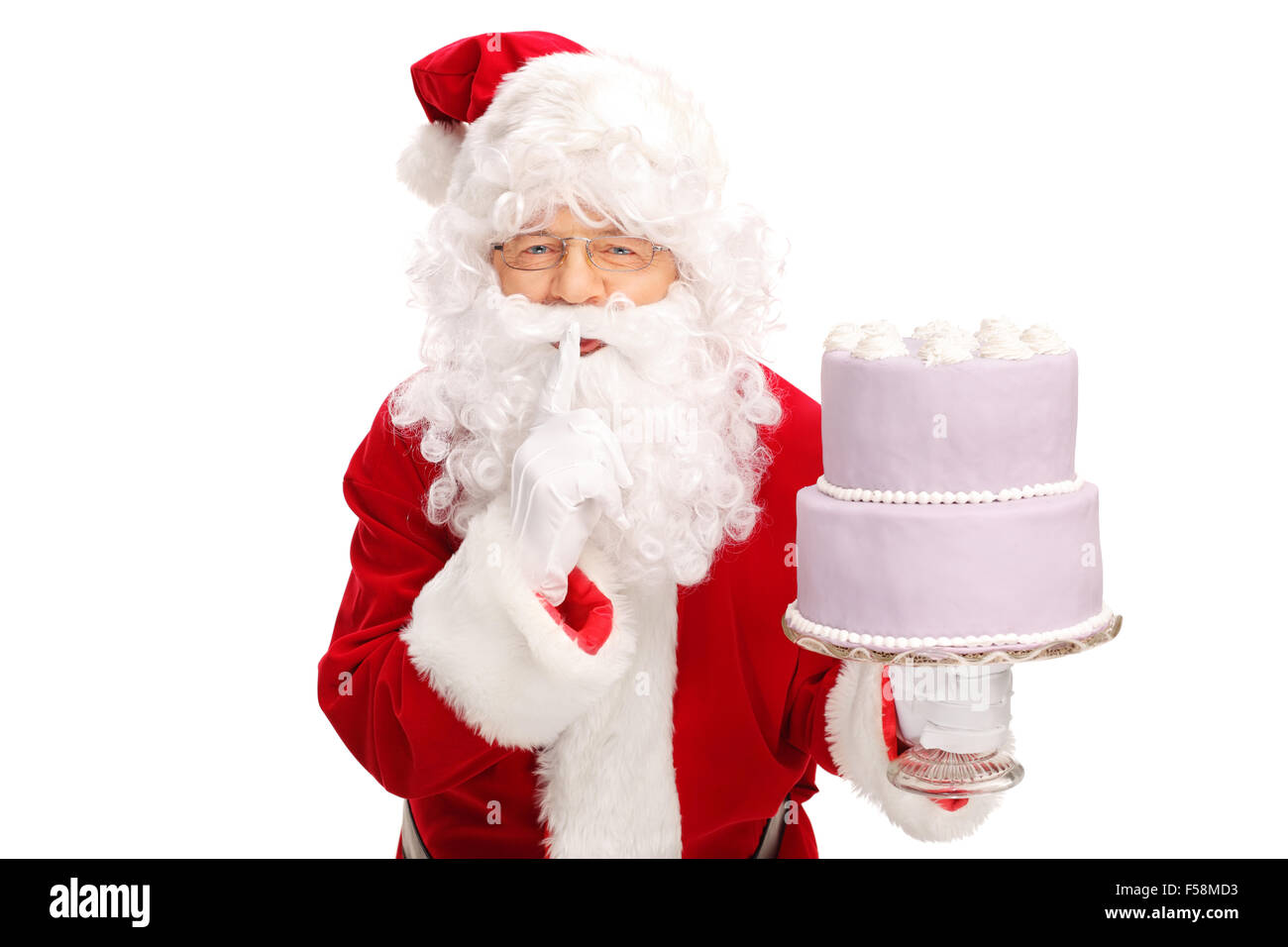 Santa Claus portant un grand gâteau et la tenue d'un doigt sur ses lèvres isolé sur fond blanc Banque D'Images