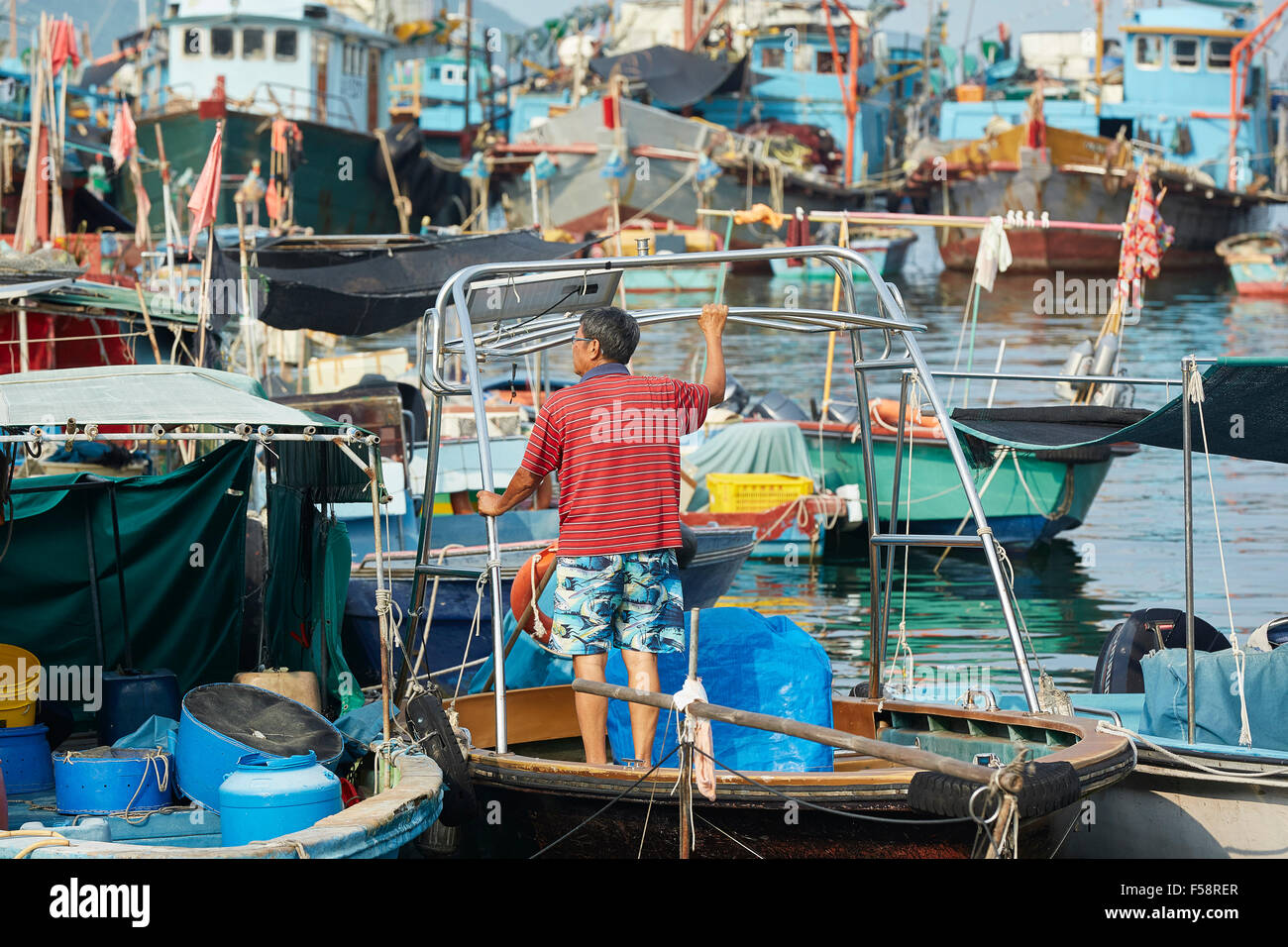 Pêcheur chinois sur un petit bateau dans le port de Cheung Chau, Hong Kong. Banque D'Images