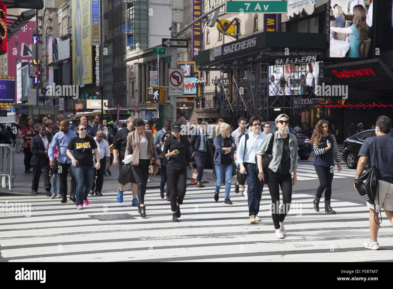 Les gens traversent la 7e avenue le long de la 42e st dans le quartier de Times Square à Midtown Manhattan, New York. Banque D'Images Les gens traversent la 7e avenue le long de la 42e st dans le quartier de Times Square à Midtown Manhattan, New York. Banque D'Images