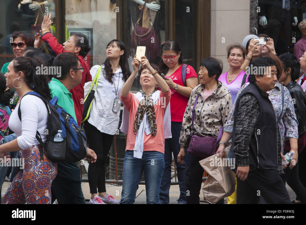Constsntly touristes prenez des photos sur leurs téléphones à Times Square, New York City. Banque D'Images