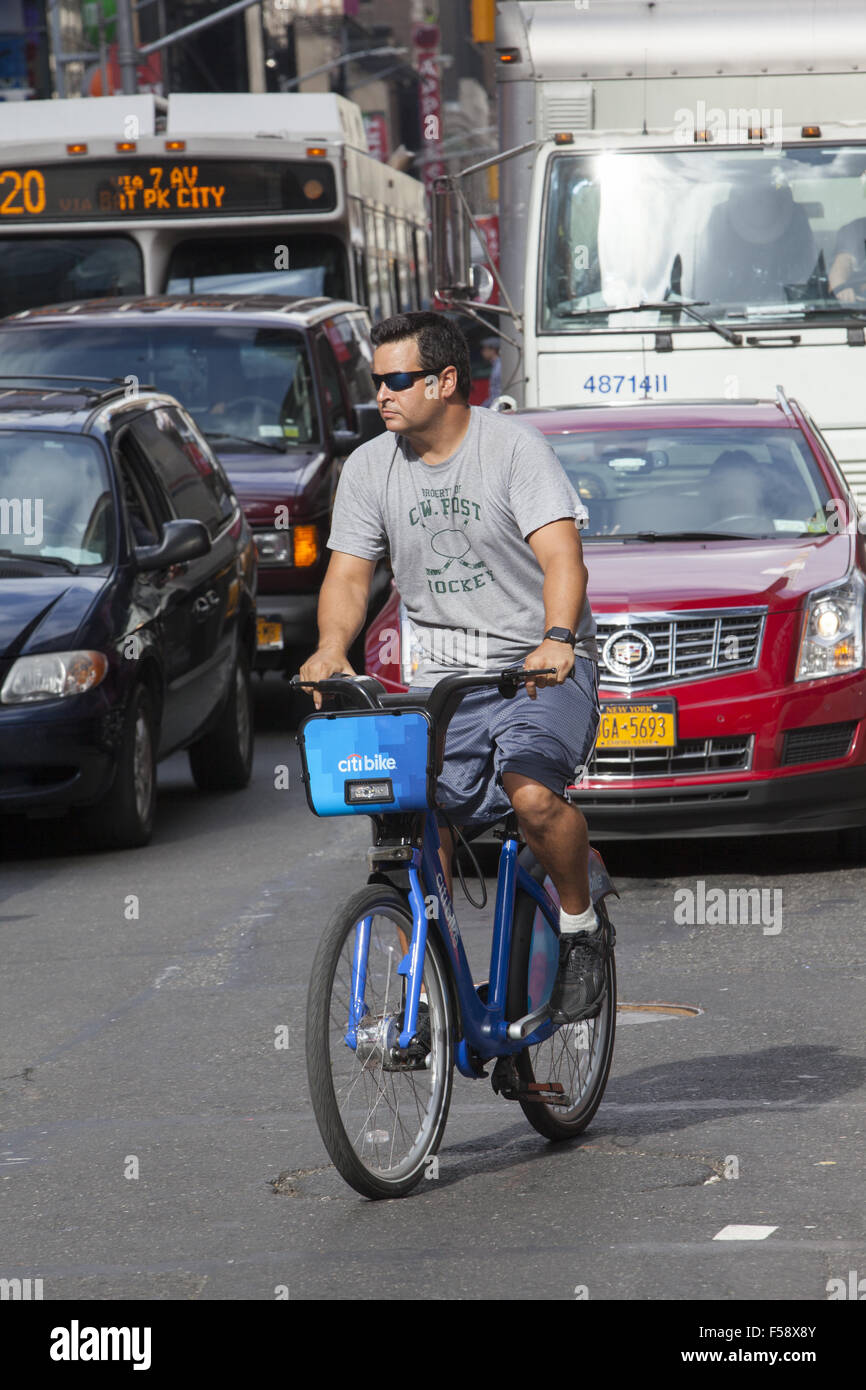 L'homme monte un vélo de Citi sur la 7e Avenue à Times Square, New York. Banque D'Images