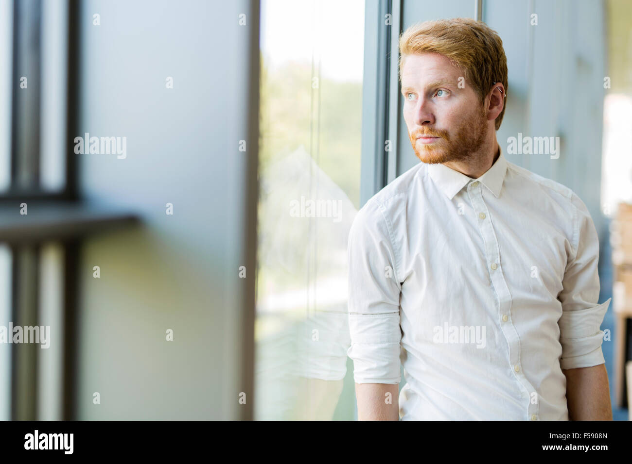 Portrait d'un homme debout près de la fenêtre Banque D'Images