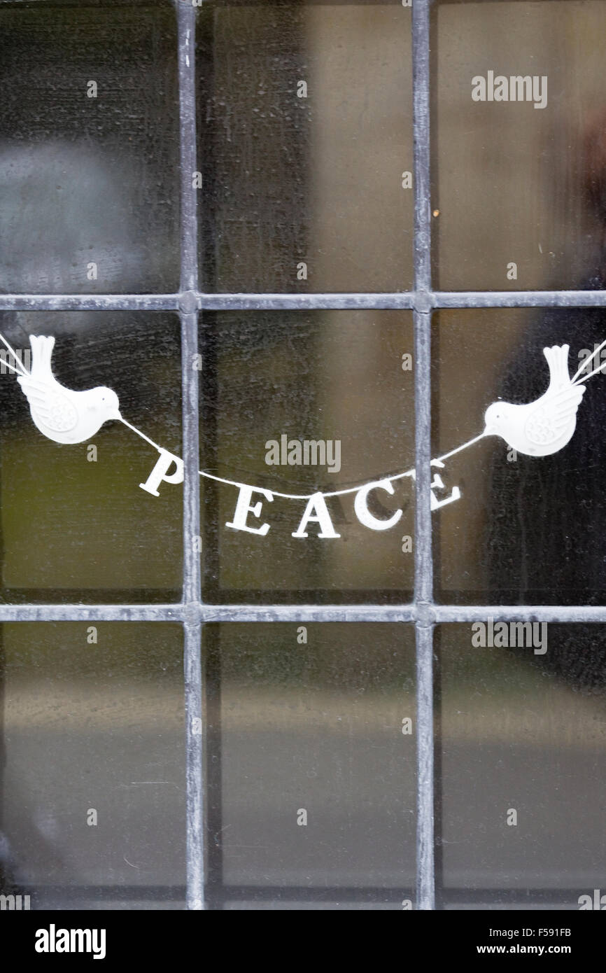 Deux colombes blanches holding la paix entre eux sur une fenêtre au plomb Banque D'Images