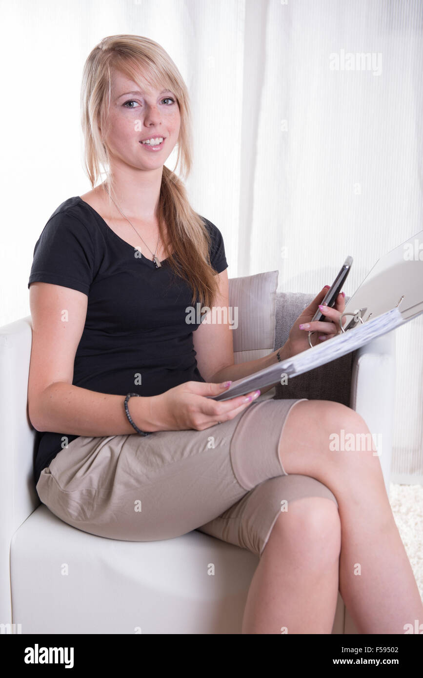 Jeune femme travaillant avec cahier sur ses genoux Banque D'Images