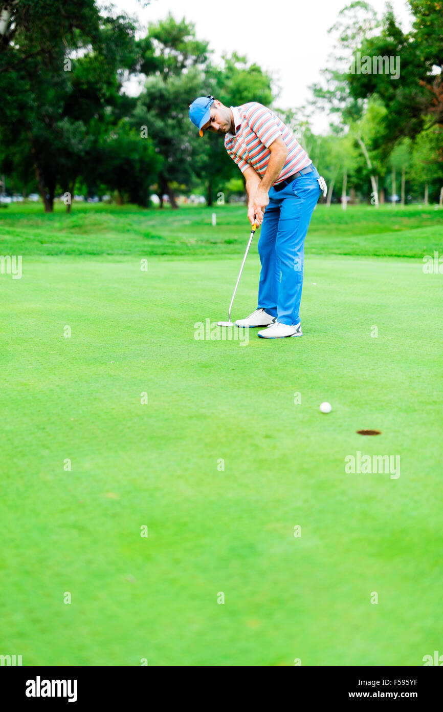 Le golfeur prend un vert tiré et la balle est la fermeture sur le trou Banque D'Images