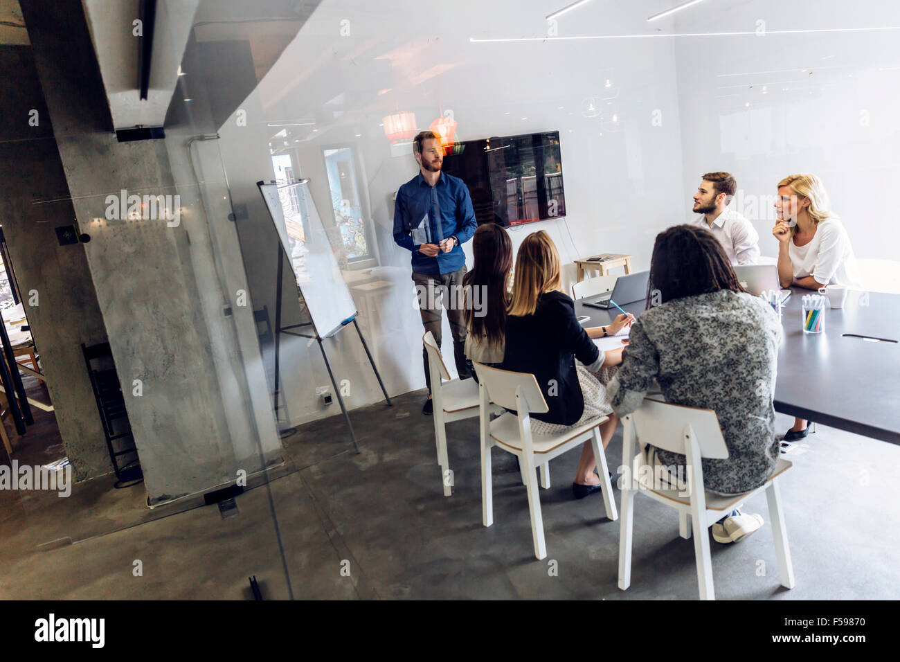 Groupe de collègues dans un bureau de brainstorming et de présentation Banque D'Images