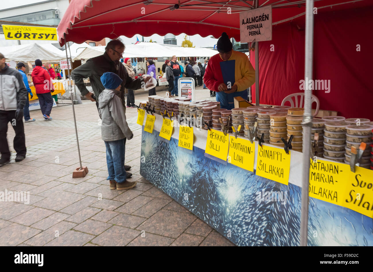 Imatra, Finlande - le 25 octobre 2015 : Les gens qui achètent le poisson conservé dans des boîtes en plastique, traditionnelle finlandaise sur une rue de saison Banque D'Images