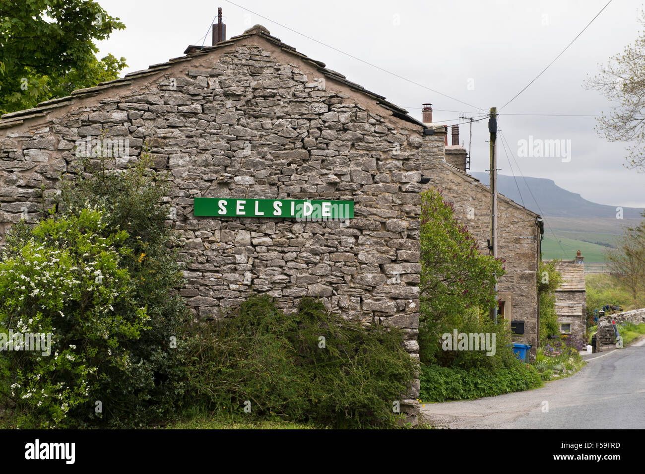 Pittoresque, traditionnelle, construite en pierre, les chalets (1) signe avec le nom du village, dans le hameau de Armoy, Yorkshire Dales National Park, England, UK. Banque D'Images