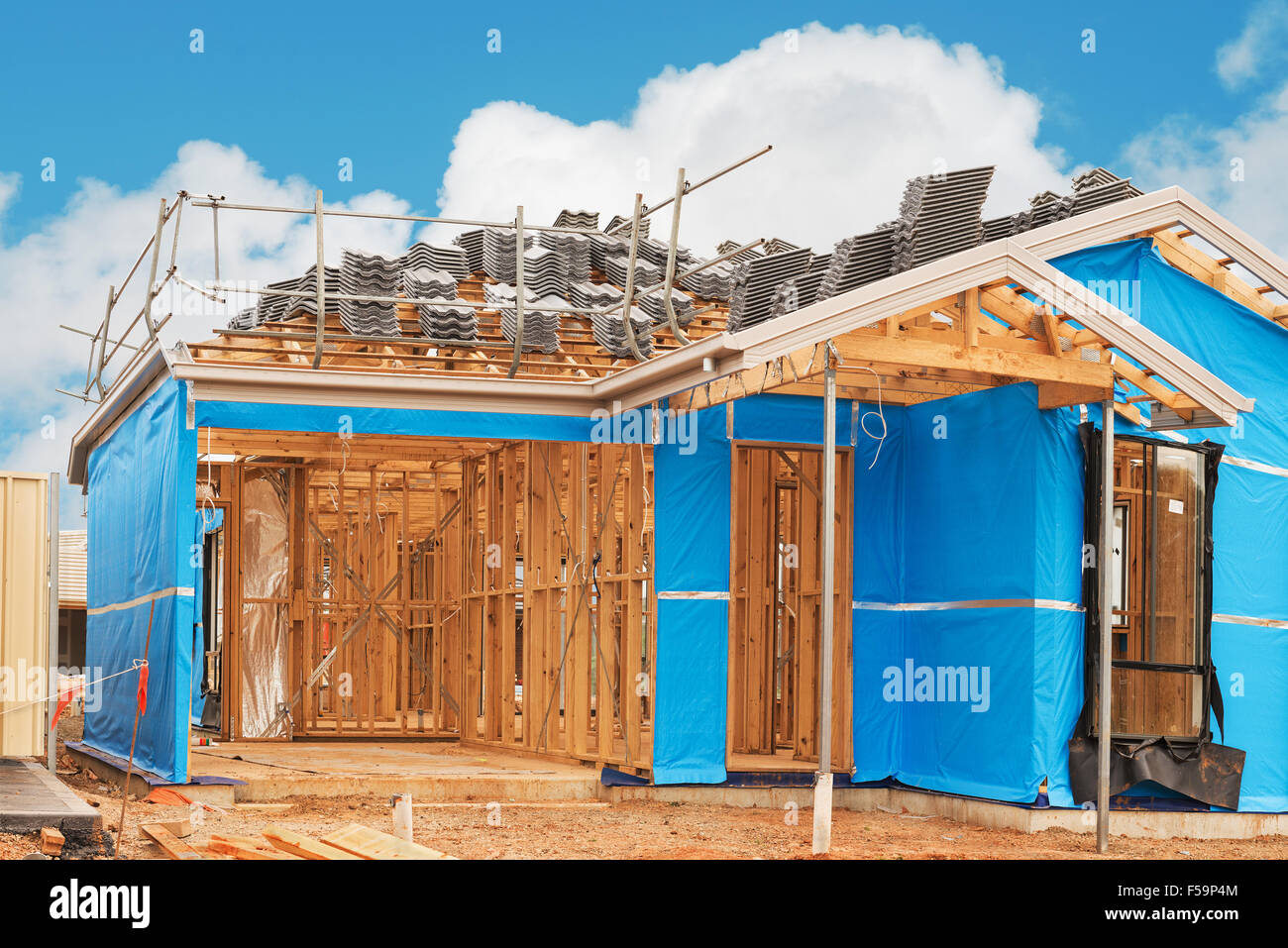 Nouvelle maison de banlieue actuellement en construction pour la préparation de travaux de toiture contre ciel nuageux Banque D'Images