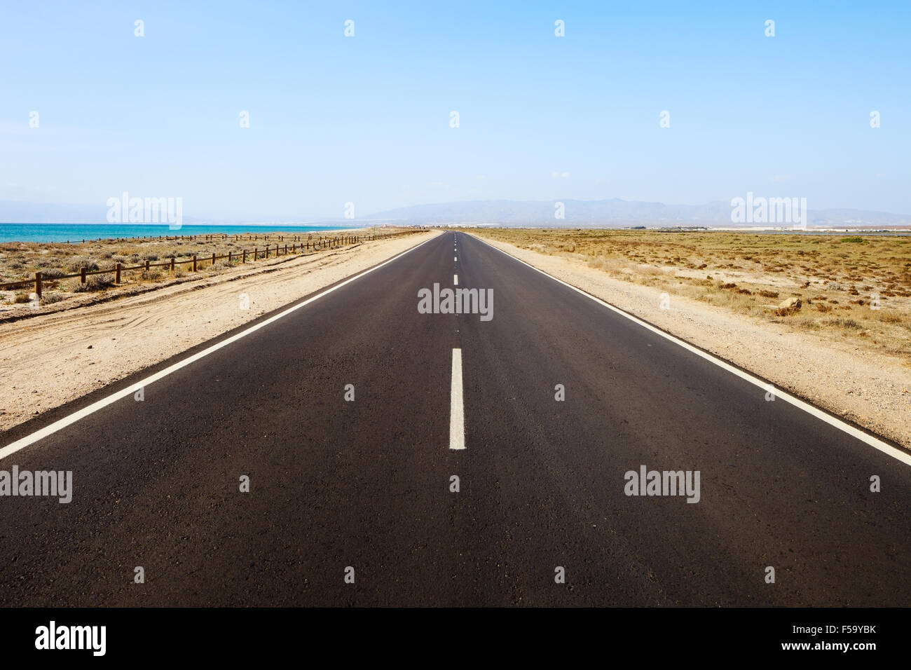 Route droite dans un désert marin dans une journée ensoleillée. L'Andalousie, espagne. Banque D'Images