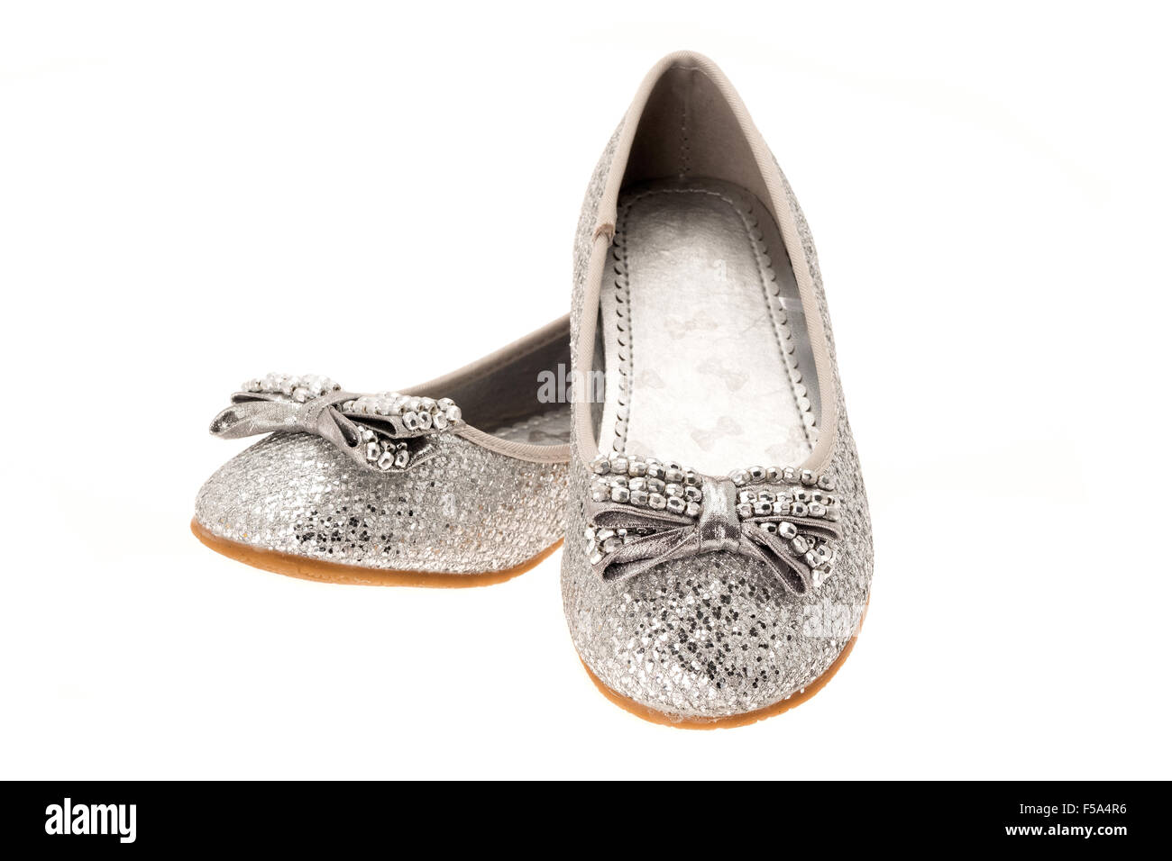 Une paire de chaussures de filles fantaisie argent partie - Fond blanc Banque D'Images