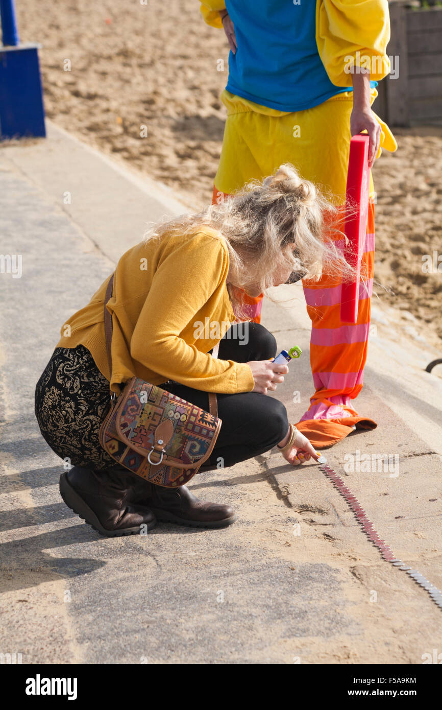 Bournemouth, Dorset, UK. 31 octobre 2015. Une tentative est en cours pour construire un mille de 10 pence-pièces entre Bournemouth et Boscombe Piers. L'événement, intitulé argent Halloween Mile, est de l'aide de l'AOK de Rucksack Appel, qui fournit des sacs à dos d'urgence d'articles essentiels aux nouveaux sans-abri recensés par les organismes professionnels. Quelqu'un a calculé qu'un mille est apparemment 1609344 millimètres, une pièce de 10 pence est de 24 mm, de sorte que dans l'hypothèse d'un mile parfaitement droit exact et sans espace de 67056 pièces de monnaie sont nécessaires, d'une valeur de $6705.60 Banque D'Images