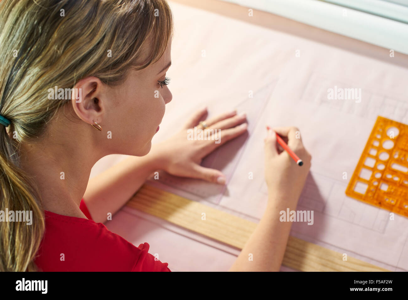 Étudiant de l'université de design d'intérieur faire devoirs, l'achèvement du projet de logement pour l'examen final. La jeune fille trace des lignes sur fond bleu Banque D'Images