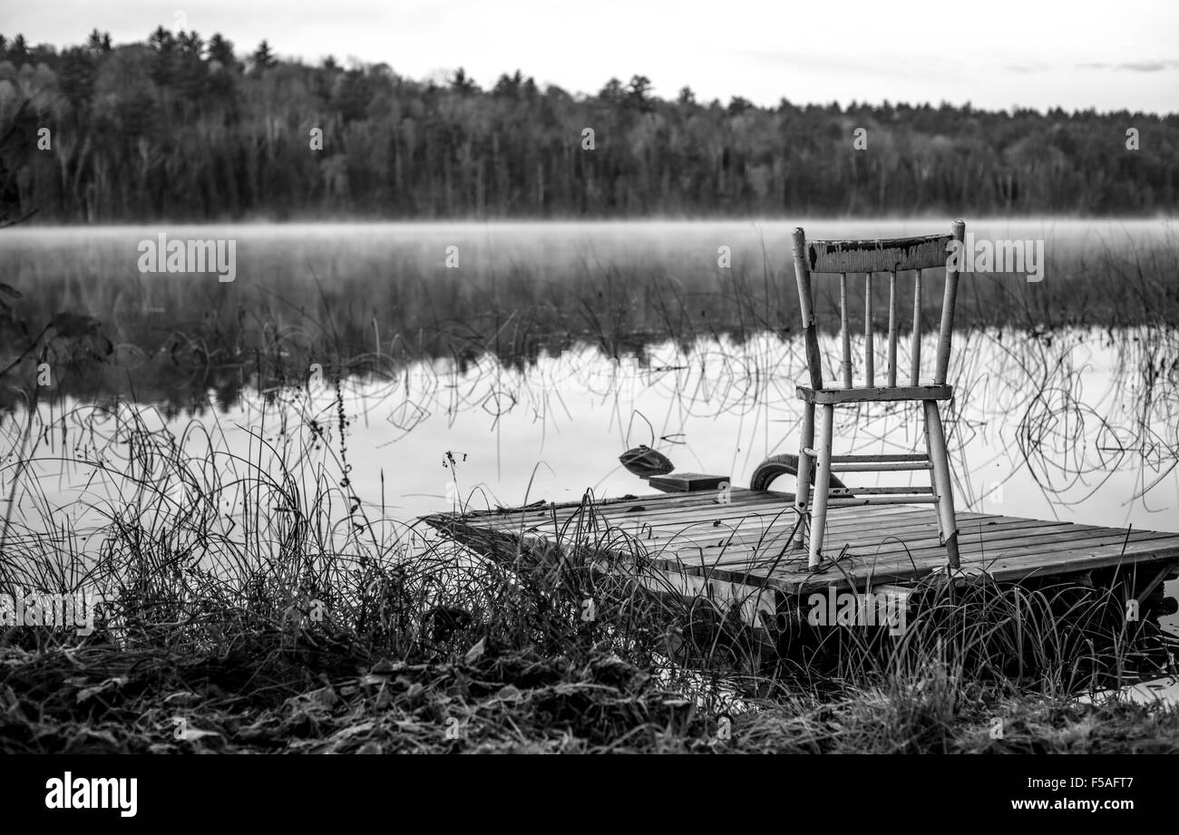 Matin d'octobre sur le lac avec un quai et une chaise au bord de lac. Banque D'Images