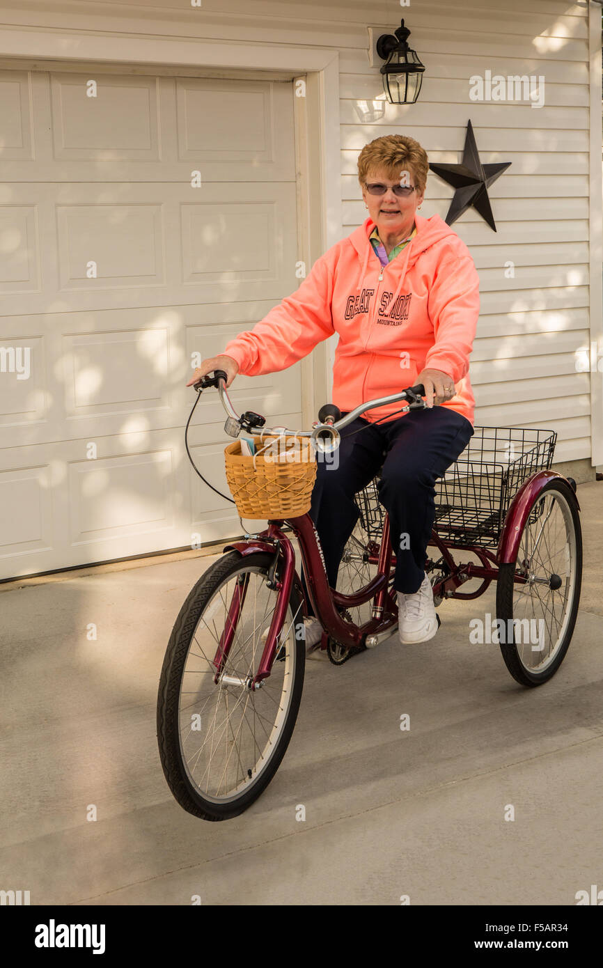 Woman riding a bicycle à trois roues à Columbus, Ohio. Les deux roues arrière s'assurer que vous êtes sûr et bloqué et ne perdra pas yo Banque D'Images