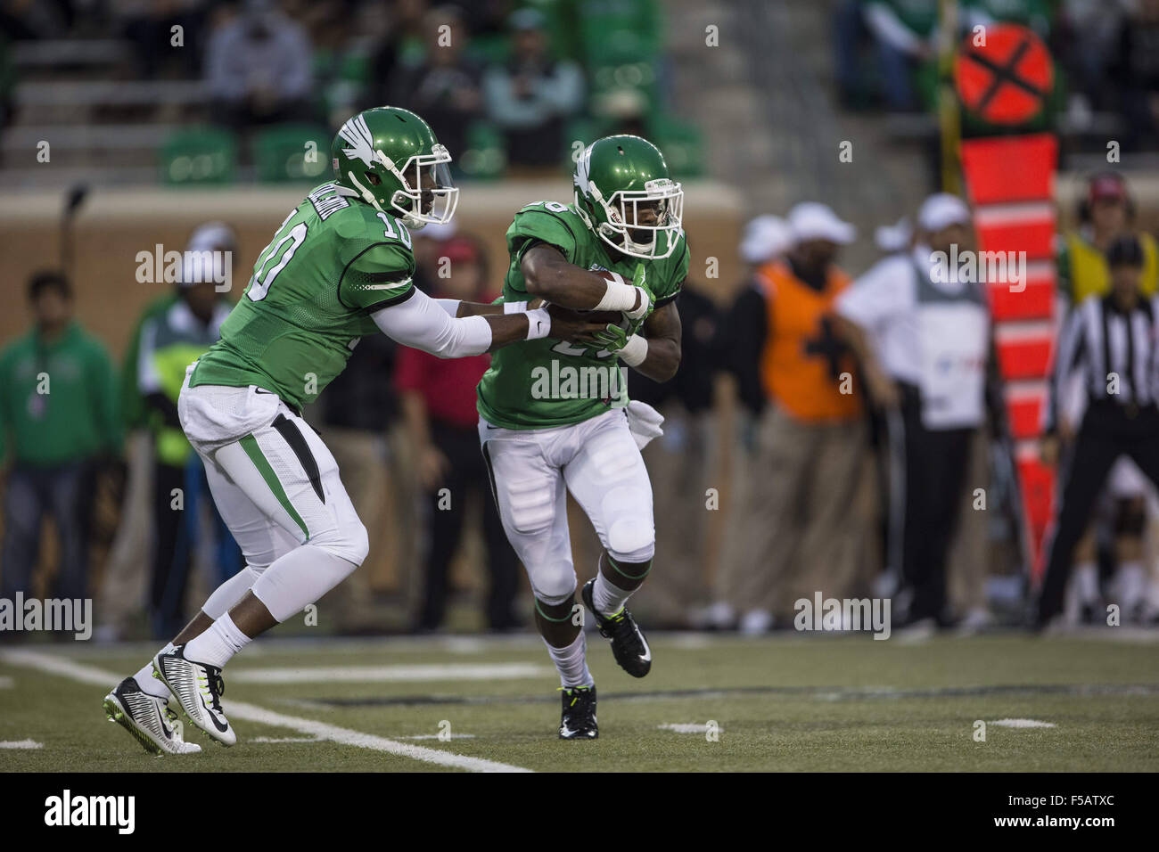 Denton, Texas, USA. 31 octobre, 2015. 31 octobre 2015 : UNT Mean Green quarterback DaMarcus Smith (10) Touche pas à utiliser de nouveau Jeffrey Wilson (26) la NCAA football match entre l'UTSA Roadrunners et UNT Mean Green chez Apogee Stadium à Denton, Texas. JP Waldron/ZumaPress © Jp Waldron/ZUMA/Alamy Fil Live News Banque D'Images