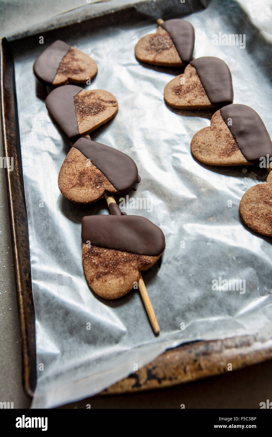 Heart-Shaped Cookies trempées dans le chocolat sur plaque Banque D'Images