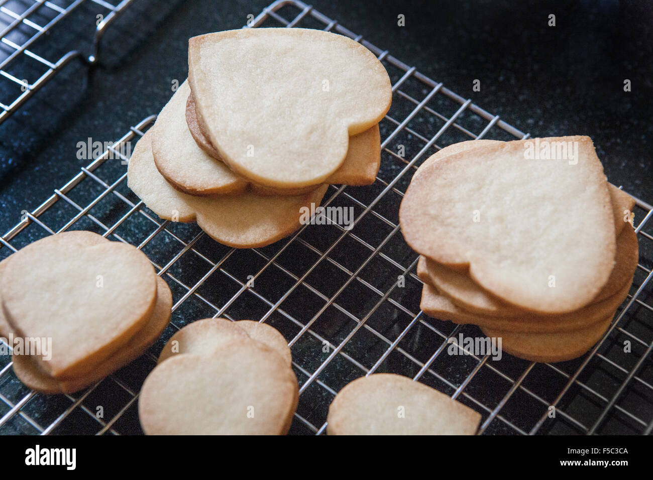 Heart-Shaped sablés, Cookies sur grille de refroidissement, Close-Up Banque D'Images