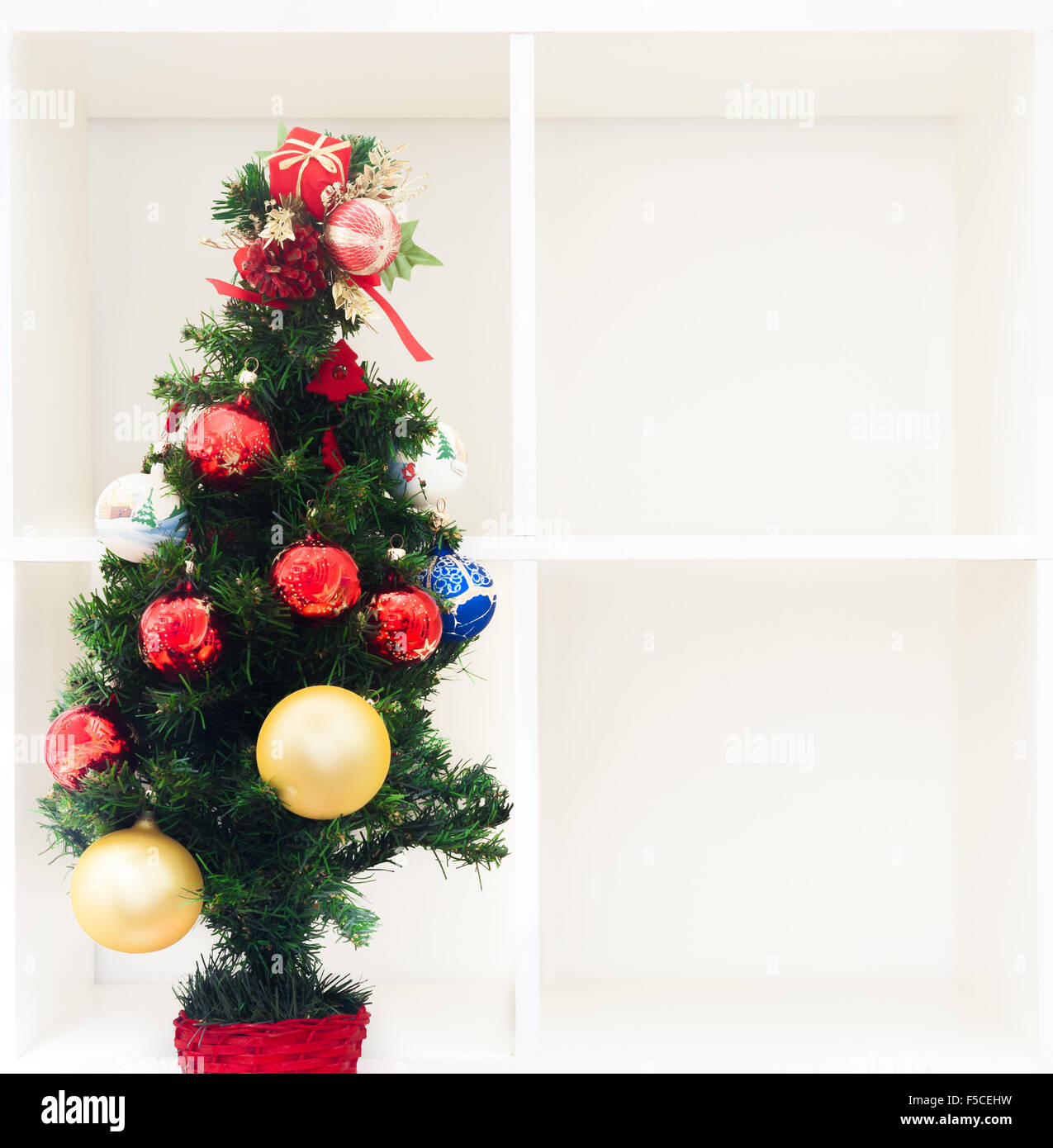 Arbre de Noël sur étagère blanche vide avec quatre boîtes cubiques et copy space Banque D'Images