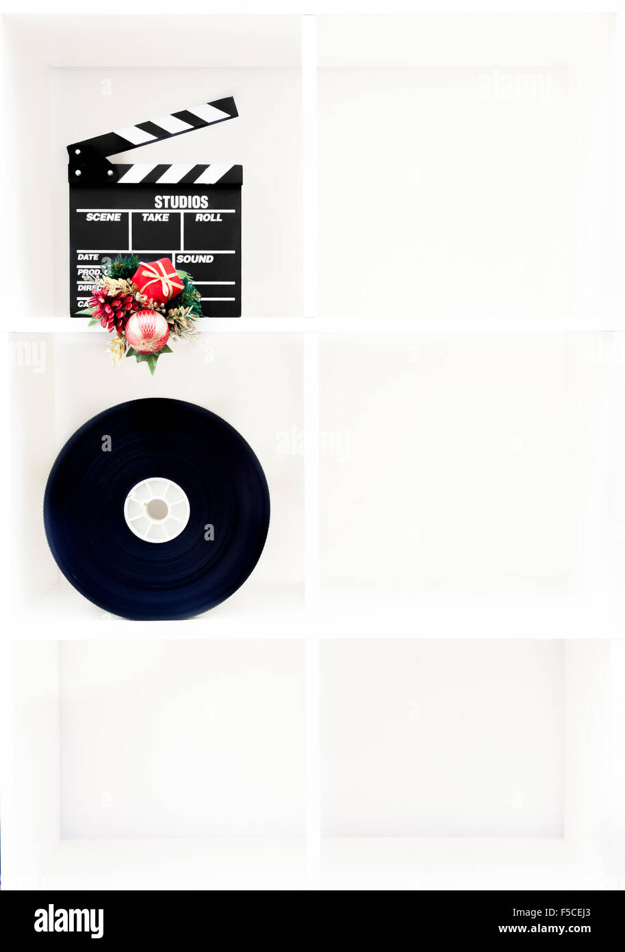 Movie clapper board, bobine de film et décoration de Noël sur étagère blanche verticale avec six boîtes cubiques et copy space Banque D'Images