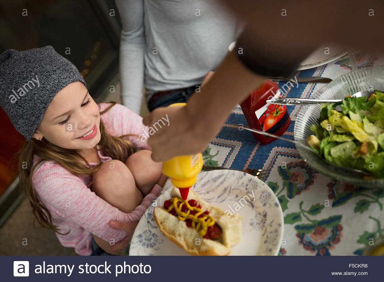 Girl squirt frère la moutarde à hot dog Banque D'Images
