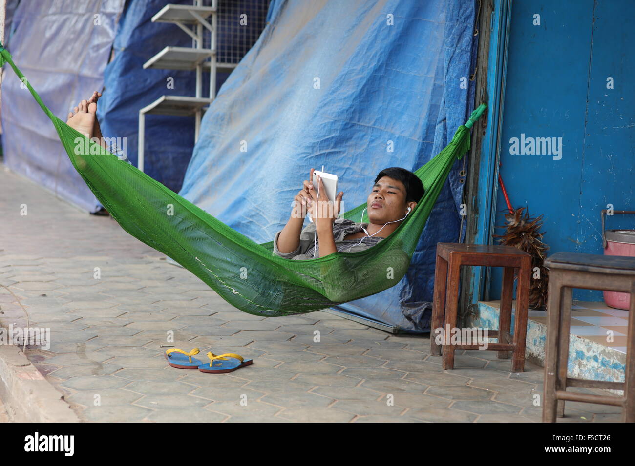 Man with smart phone in Hammock Banque D'Images
