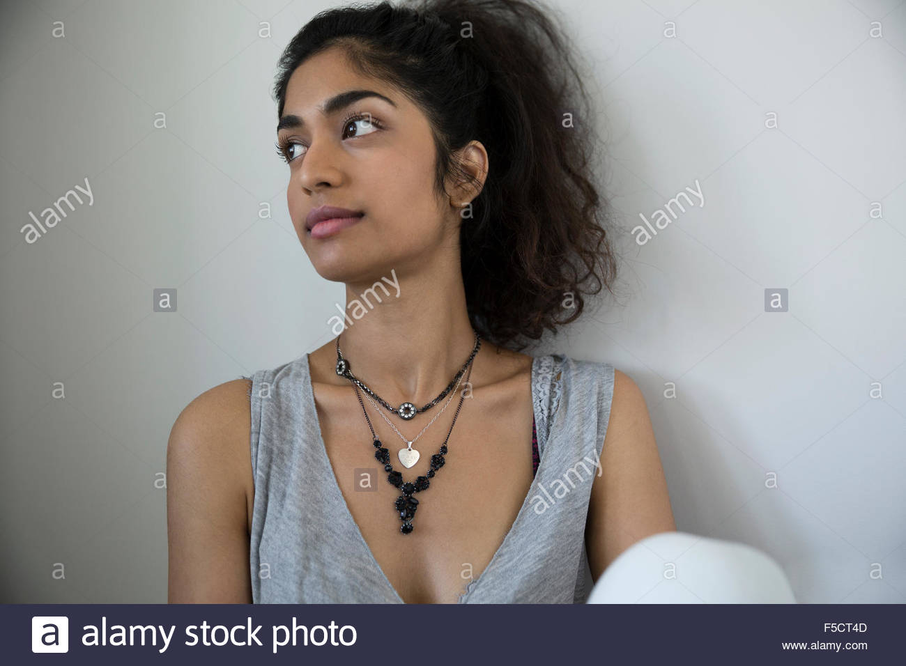 Pensive young woman with black hair looking away Banque D'Images
