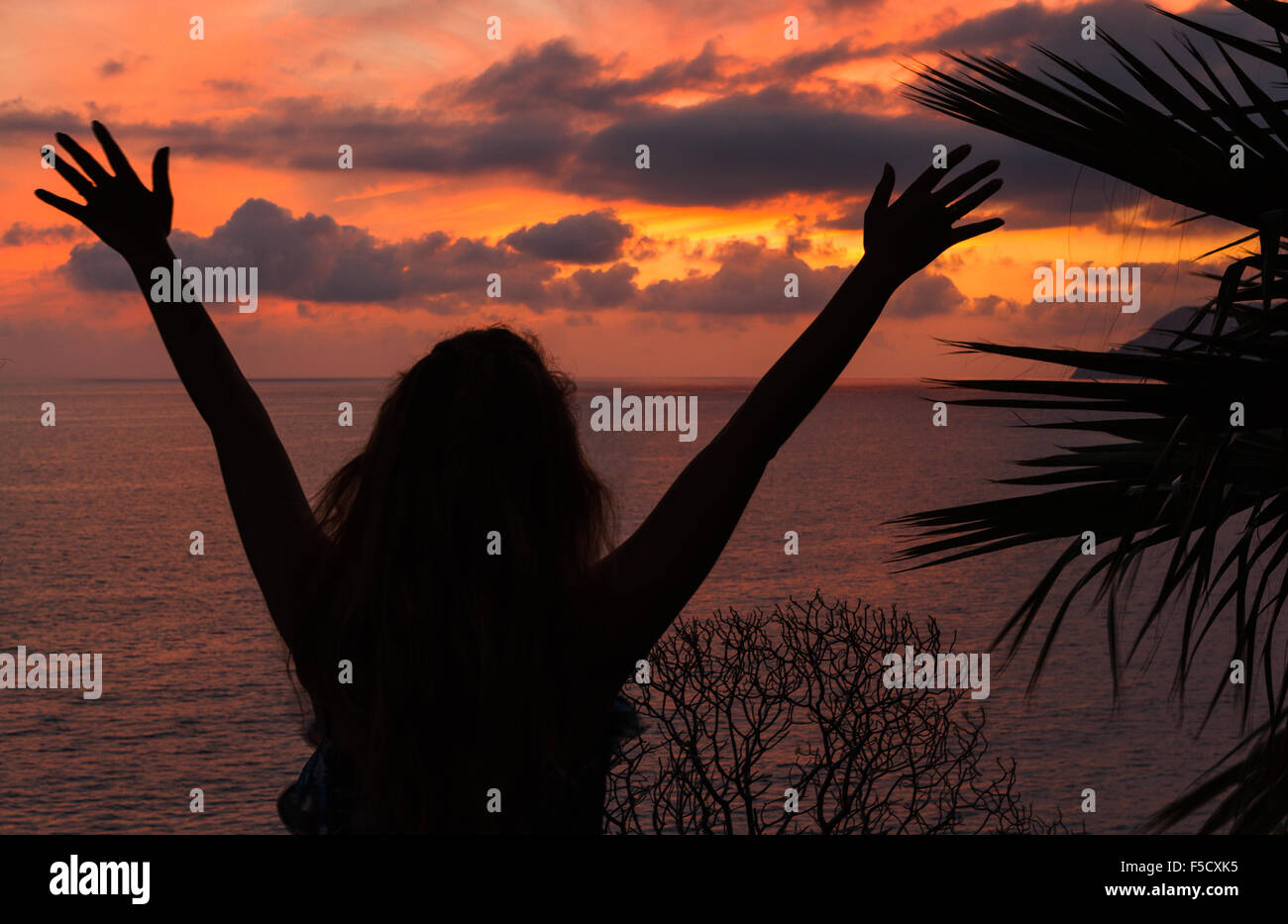 La silhouette d'une jeune femme de race blanche par le coucher du soleil à Manarola, dans les Cinque Terre (Cinq Terres), Parc National de Ligurie, Italie. Banque D'Images