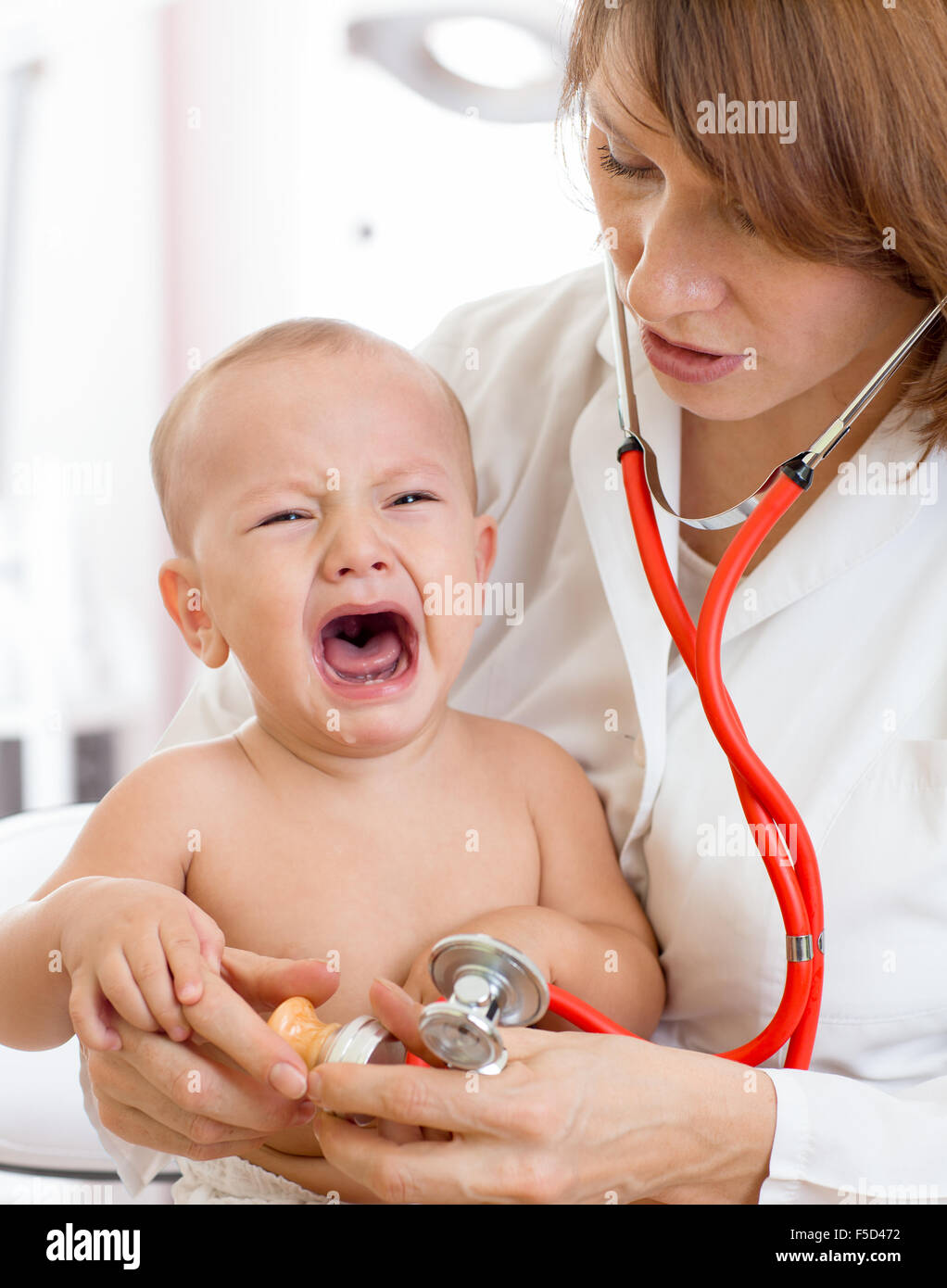 Médecin pédiatre avec bébé qui pleure Banque D'Images