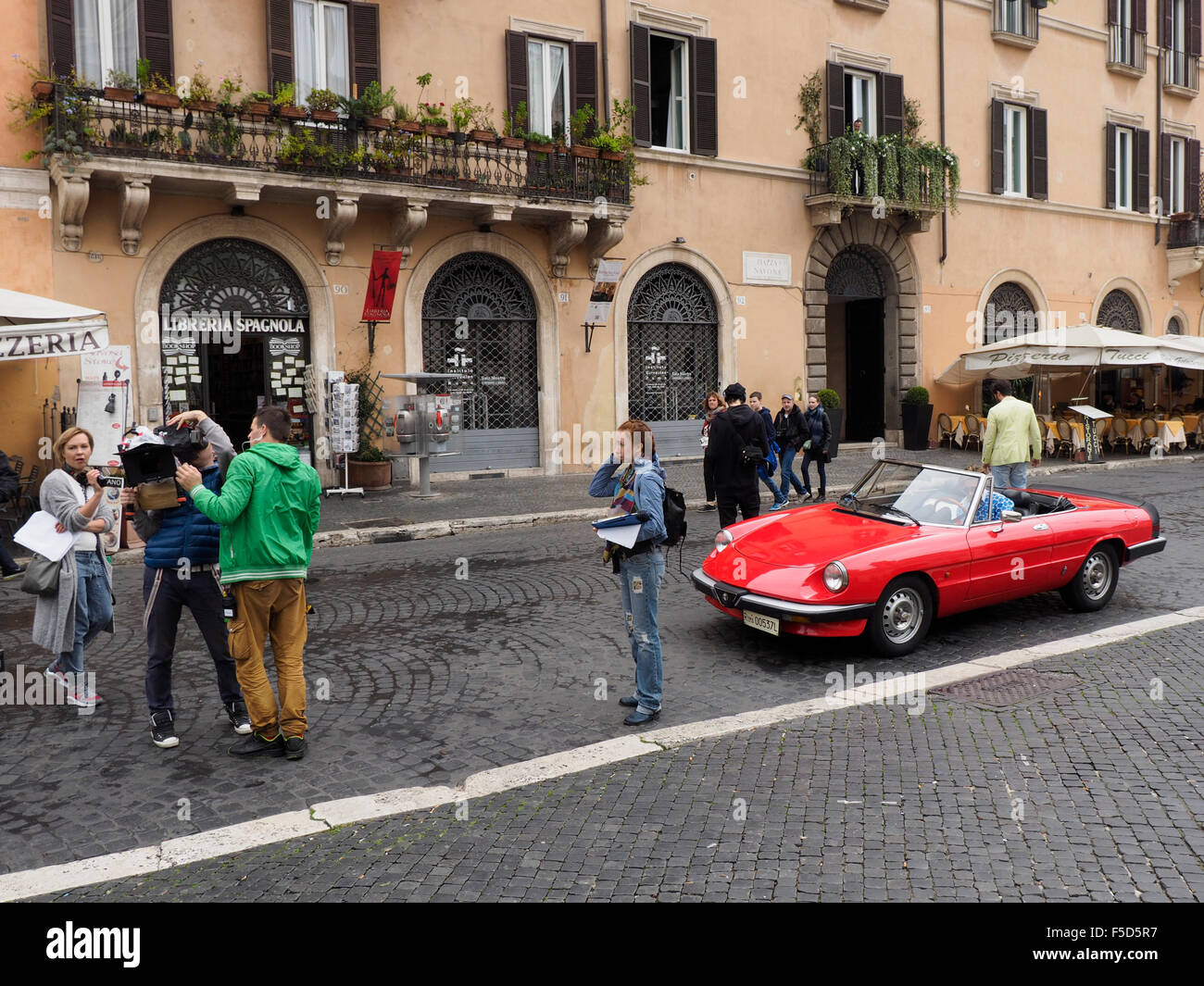 L'équipe du film et des modèles masculins dans une Alfa Romeo classique des voitures de sport sur la Place Navone à Rome, Italie Banque D'Images