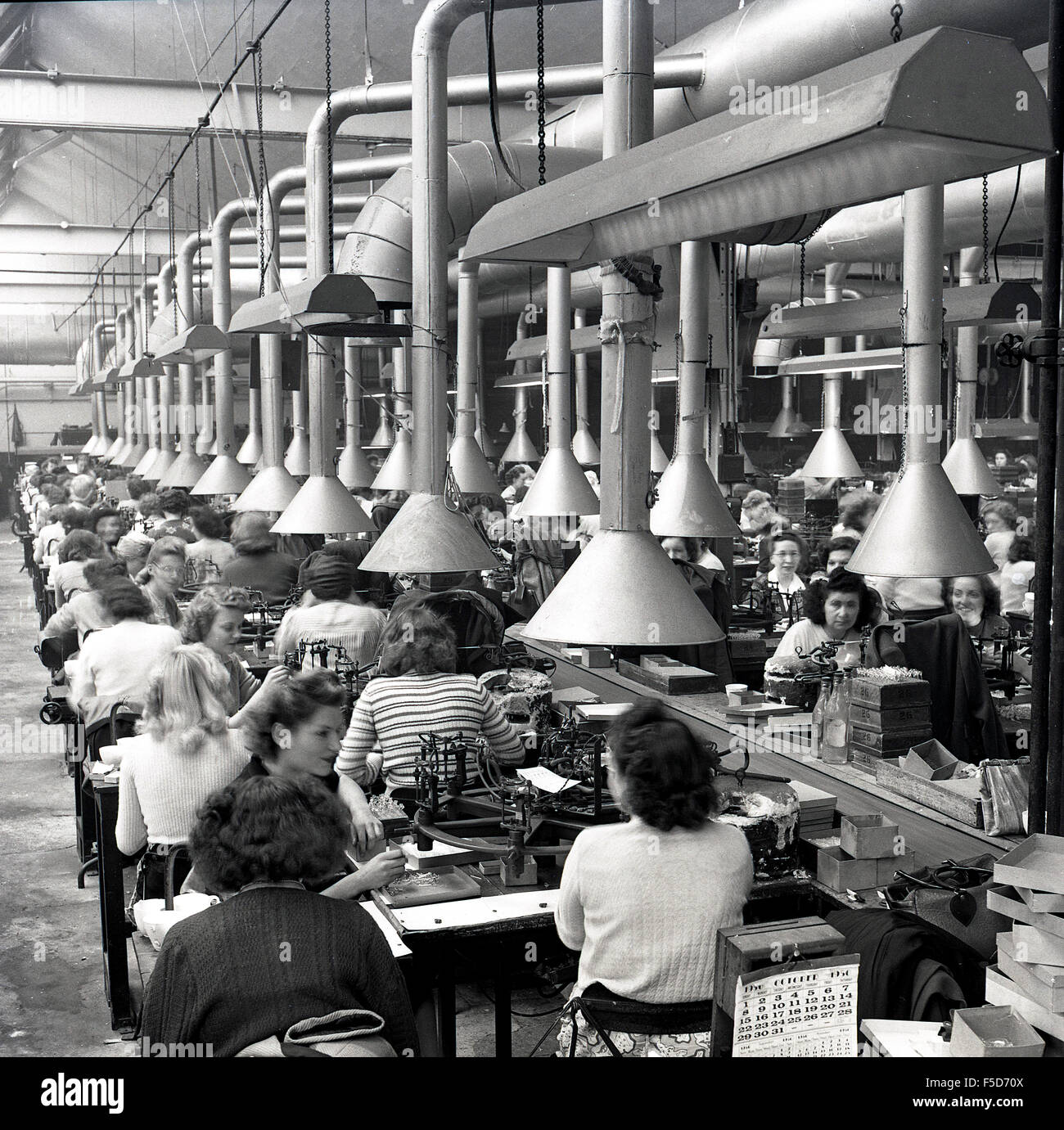 Octobre 1950 et l'historique des lignes de femmes au travail sur une ligne de production en usine. Banque D'Images