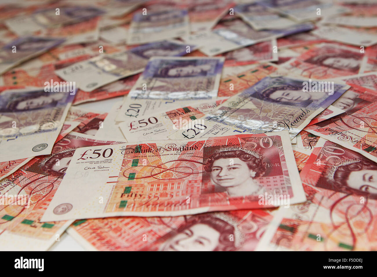 Pile de £50 et £20 UK Pound note avec une note de 50 € proéminent. Banque D'Images