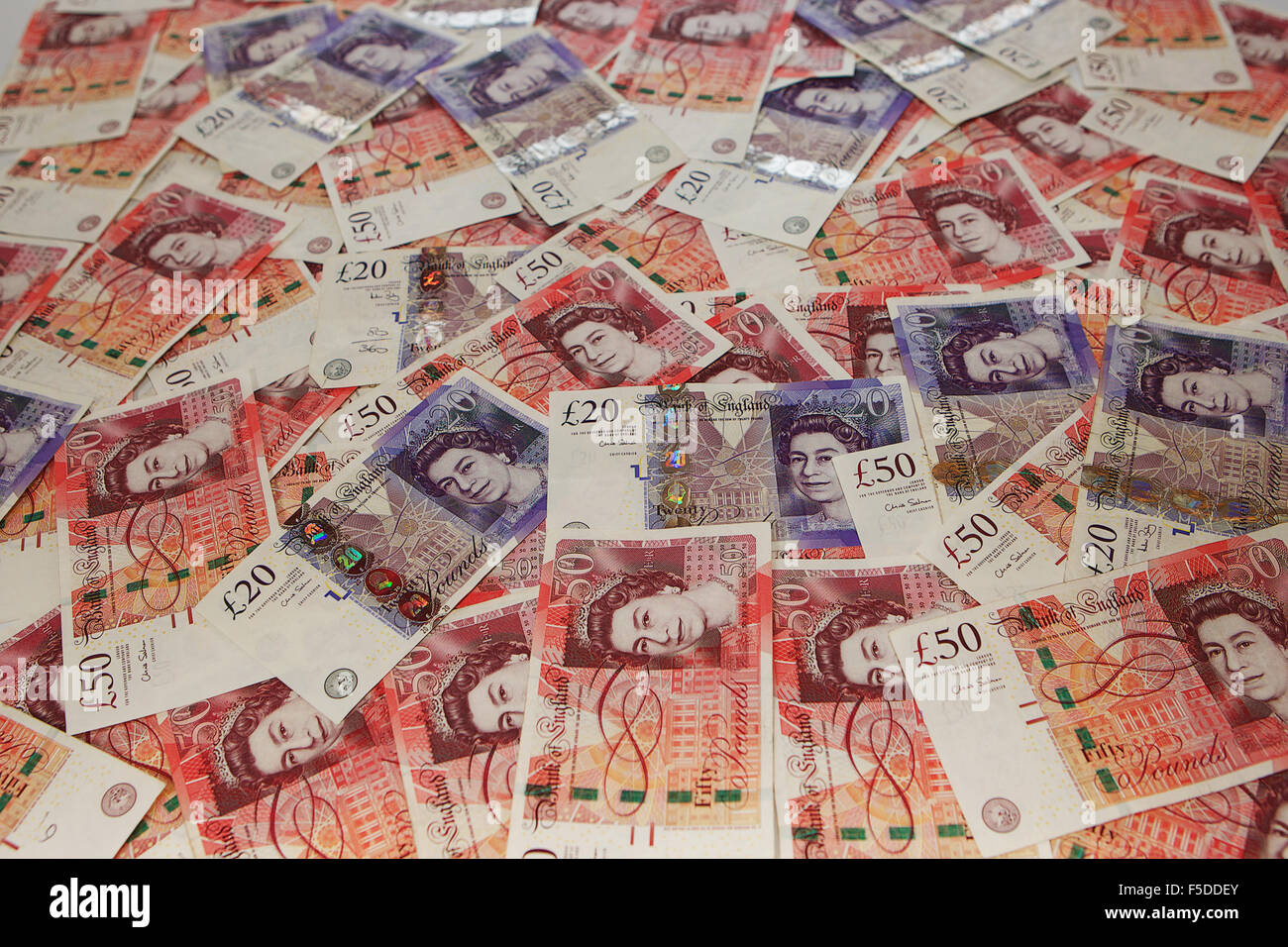 Pile de £20 et £50 notes éparpillées. Banque D'Images