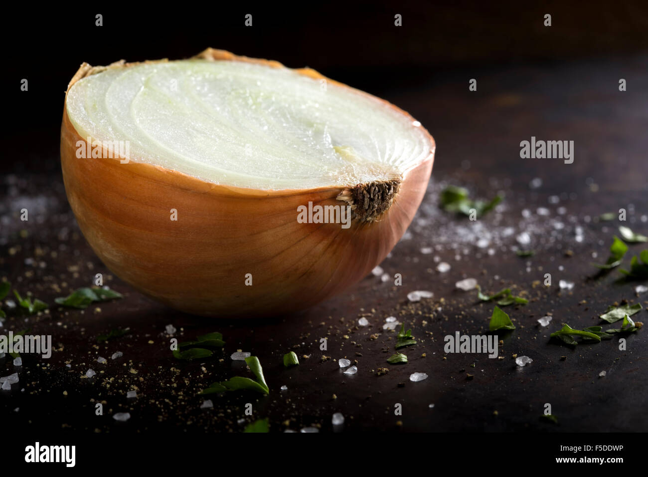 Oignon mûrs sur un fond rustique avec du sel et des herbes Banque D'Images
