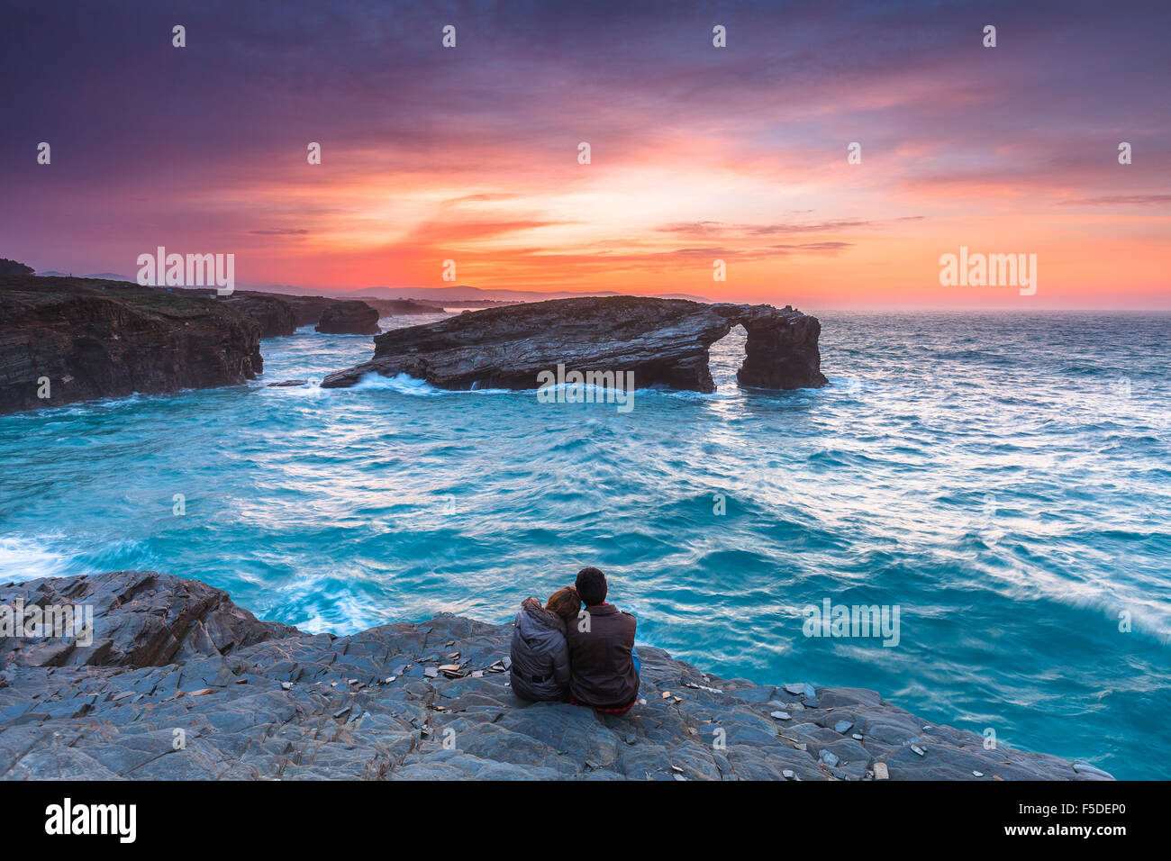 Un couple enjoying sunset dans 'comme Catedrais' / 'Las Catedrales Beach', Ribadeo, Lugo. La Galice, Espagne. Banque D'Images