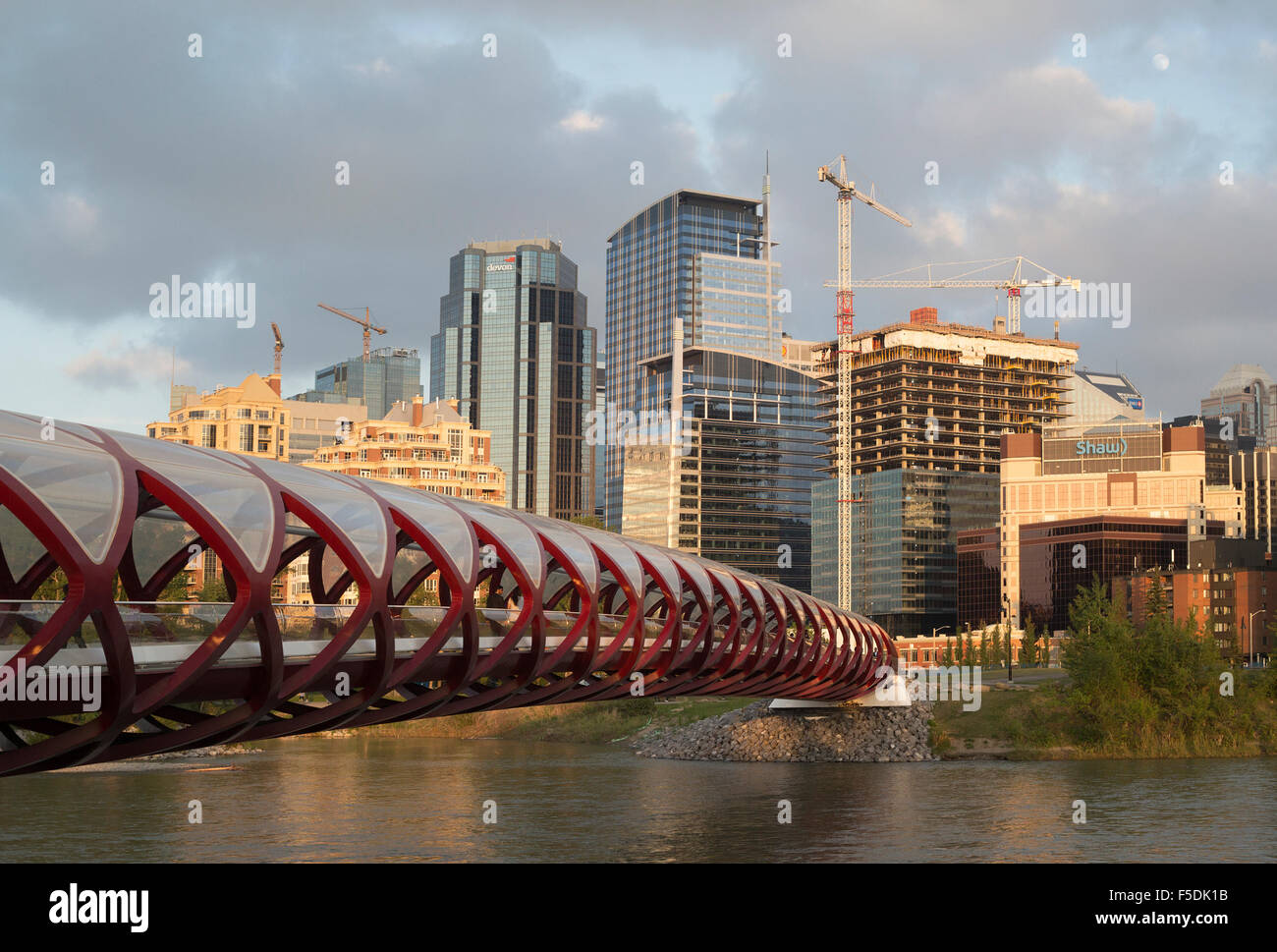 Les grues de construction et de bureau en construction dans le centre-ville de Calgary, Peace Bridge en premier plan Banque D'Images